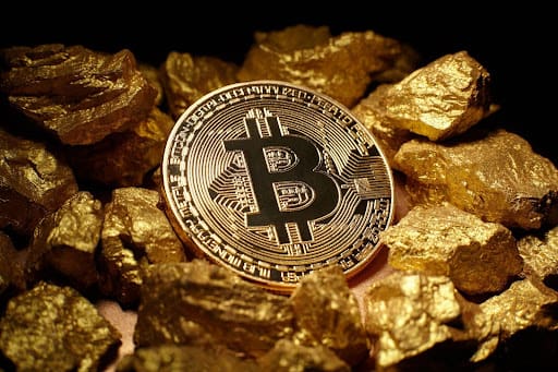 Een berg fysieke Bitcoin munten, met één rechtopstaande munt waarop het Bitcoin logo staat.