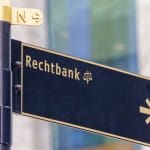 Een afbeelding van een verkeersbord die de richting aanwijst naar de rechtbank