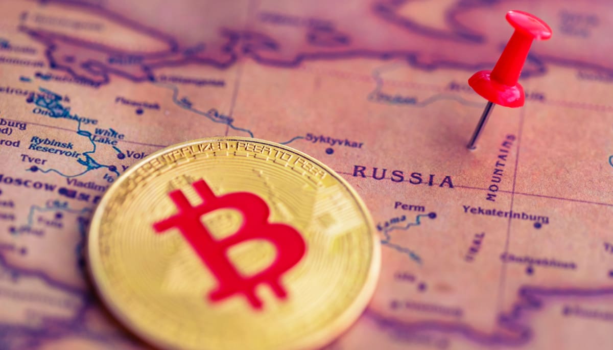 Een afbeelding van een bitcoin (BTC) munt naast een pin op het land Rusland