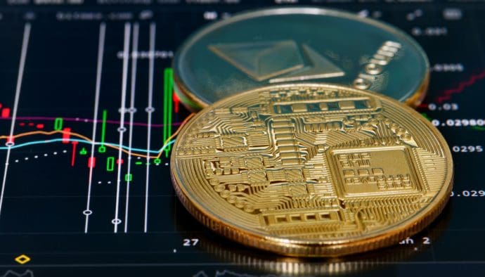Een afbeelding van een ethereum (ETH) en een bitcoin (BTC) munt op een grafiek met marktdata