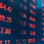 Een afbeelding van een scherm met zeer rood kleurende aandelen en crypto prijzen