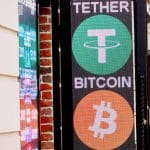 Een afbeelding van het tether logo op een uithangbord met daaronder het logo van bitcoin (BTC)